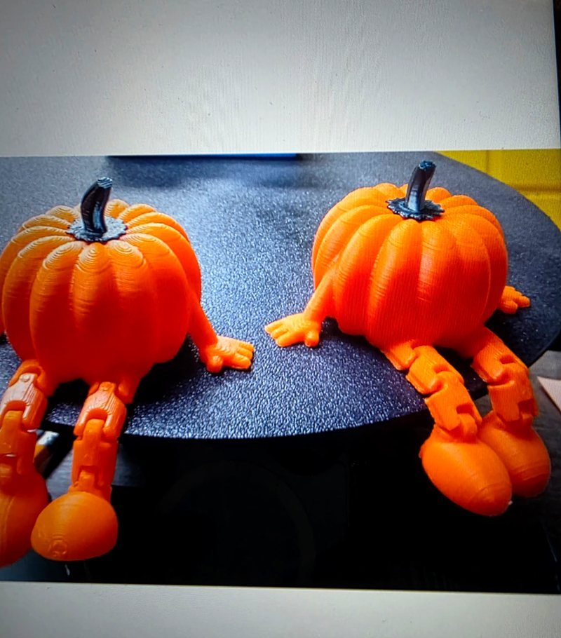 Two orange pumpkins with articulated, jointed legs and feet.