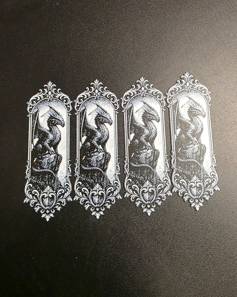 Four bookmarks printed with a dragon in an ornate frame design.