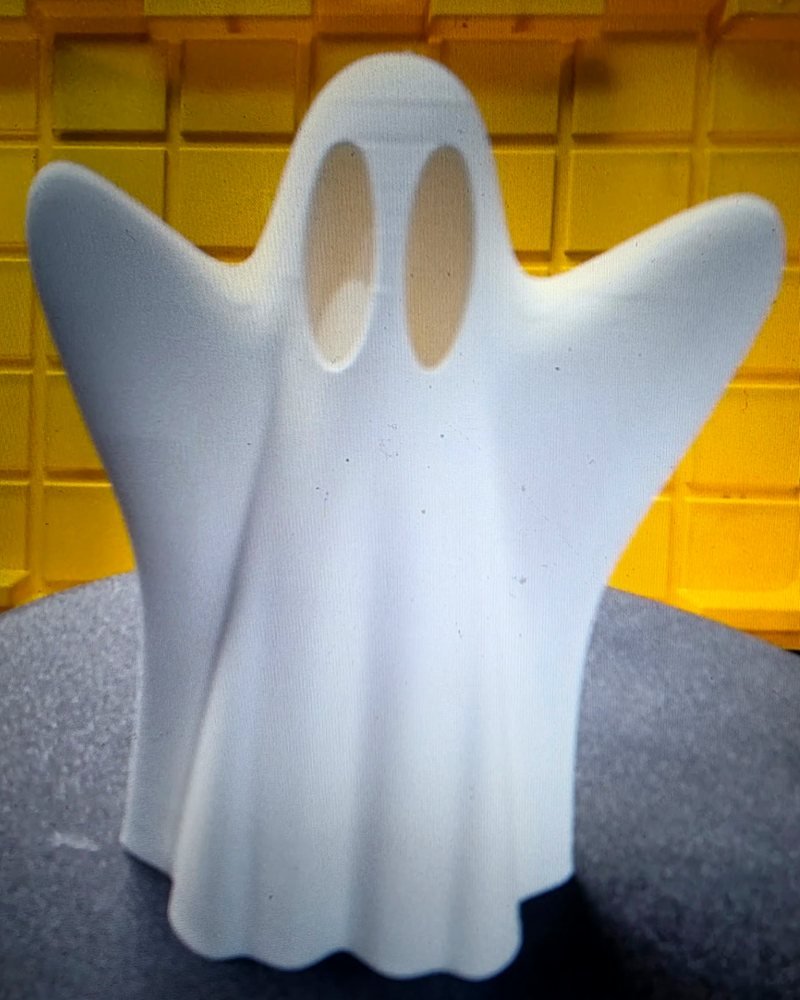 A white sheet ghost with two large hollow eyes and arms stretched out.