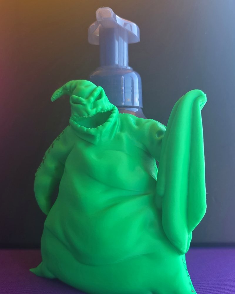 A bright green Oogie Boogie figure with a foaming soap pump bottle standing behind it.