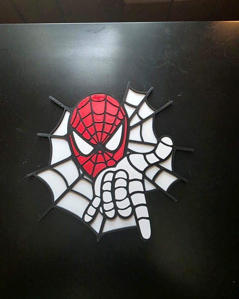 A Spider-Man mask bursting through a spider web, printed as a red, white, and black wall-mount plaque.